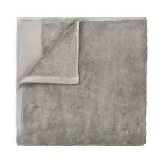 a gray and white blanket folded on top of each other