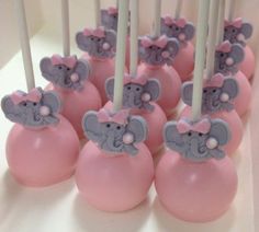 pink and gray cake pops with elephants on them are ready to be served at a baby shower