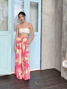 Step into a soft dreamscape of color with our Summer Tie-Dye Wide-Leg Pants. The perfect choice of vacation wear, these flared pants reflect free-spirited chic, letting you float through summer in unconfined comfort. Handcrafted from 100% Rayon, they offer exceptional breathability and a fluidic drape that keeps you cool and light as air all summer. It features an elasticated drawstring waist that offers an adjustable fit and side pockets for a practical flair. The vibrant tie-dye patterns captu Summer Festival Wide-leg Harem Pants, Summer Vacation Wide-leg Harem Pants, Summer Wide-leg Harem Pants, Wide Leg Harem Pants For Beach Season, Tie Dye Beachwear Bottoms For Beach, Hippie Pink Wide Leg Bottoms, Hippie Wide Leg Pink Bottoms, Hippie Style Wide Leg Pink Bottoms, Pink Wide Leg Pants For Vacation