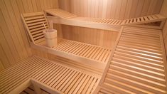 the inside of a wooden sauna with three shelves and two cups on each shelf