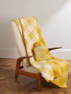 a chair with a yellow and white plaid blanket on it