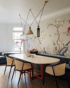 a dining room table with chairs around it and wallpaper on the walls behind it