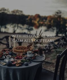 a table topped with food and a candle on top of it next to a lake