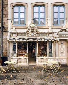 an old building with tables and chairs outside