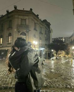 a woman is walking down the street at night with her back to the camera and she's covering her face