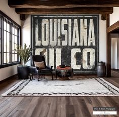 a living room with a large sign on the wall next to a chair and ottoman