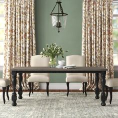 a dining room table with four chairs and a chandelier