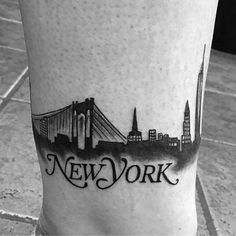 a black and white photo of a new york city skyline tattoo on the side of a man's leg