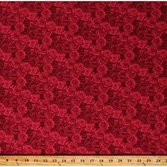 a red background with roses on it and a ruler in the foreground for scale