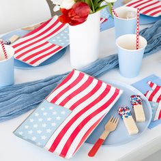 a patriotic table setting with red, white and blue napkins