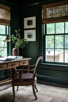 a room with green walls and two chairs in front of a desk that has an open book on it