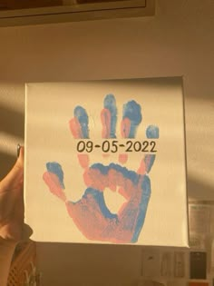 a person holding up a handprinted sign with the date 09 - 05 - 22