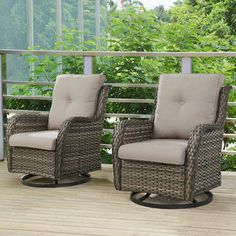 two wicker chairs sitting on top of a wooden deck next to each other with trees in the background