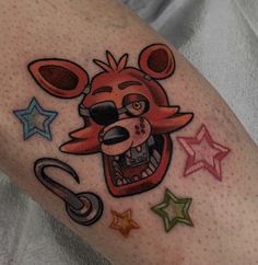 a tattoo on the leg of a person with an animal head and stars around it