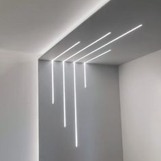 an empty room with white walls and lights on the ceiling is shown in this image