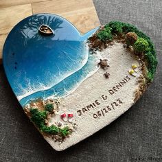 a heart shaped plaque with a beach scene on it