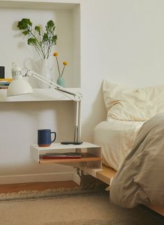 a bedroom with a bed, nightstand and lamp on the side table next to it