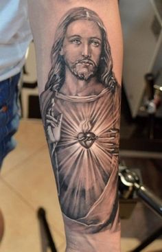 a man's arm with a tattoo of jesus on it