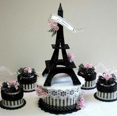 the cake is decorated in black and white stripes, with pink flowers on each tier