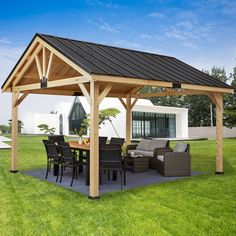 a patio covered with furniture and an outdoor dining table in the middle of a grassy area