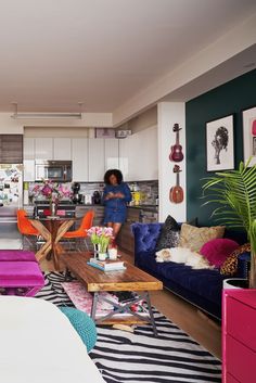 a living room filled with furniture next to a kitchen