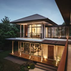 a house that is lit up at night with lights on the porch and stairs leading to it