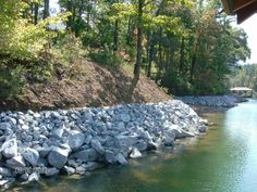 a river with rocks and trees in the background