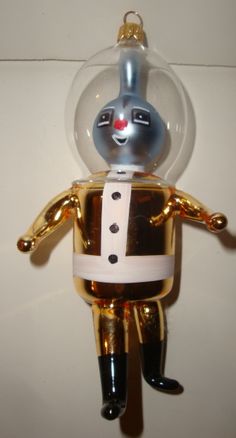 a gold and black robot ornament hanging from a wall