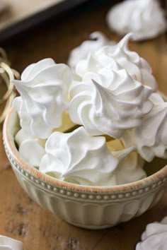 a bowl filled with whipped cream on top of a wooden table