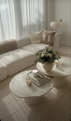 a living room filled with furniture and a white table in front of a large window