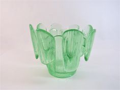 a green glass vase sitting on top of a white table