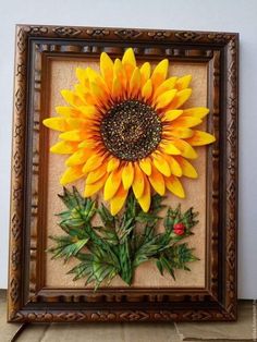 a sunflower is in a frame on the floor