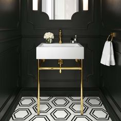 a white sink sitting under a mirror next to a wall mounted faucet in a bathroom