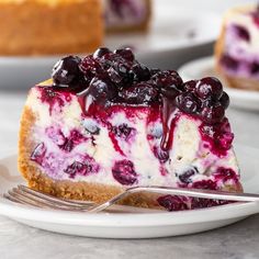 a slice of blueberry cheesecake on a plate with a fork next to it