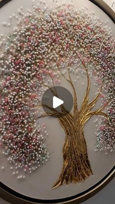 a white and gold tree with lots of small beads on it's branches is featured in the video