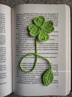 an open book with a crocheted shamrock on it's cover and the pages are opened