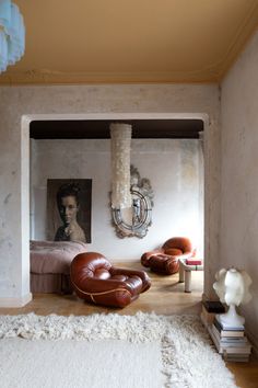 a room with a bed, chair and pictures on the wall