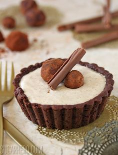 there is a chocolate cupcake with white frosting and cinnamon on the top, surrounded by other dessert items