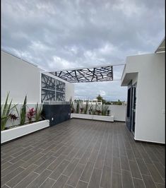 an outdoor patio with potted plants and wooden flooring