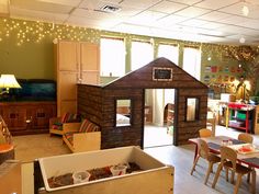 a child's playroom with wooden furniture and lights on the ceiling is filled with children's toys