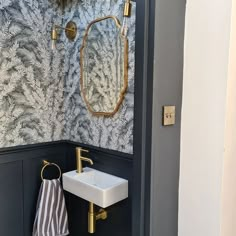 a bathroom with a sink, mirror and gold faucet in the shower stall