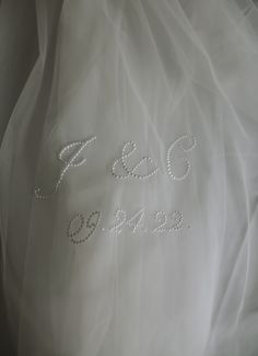 an embroidered wedding dress with the word e & g on it