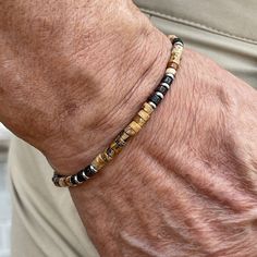 Men's beaded bracelet features: ~ 4mm Picture Jasper heishi beads ~ 4mm Bronzite heishi beads ~ 4mm Stainless Steel spacer beads ~ Stretchy cord; simply slide bracelet on and off wrist ~ Comes packaged in a re-usable microfiber pouch. To ensure the perfect fit, please use the bracelet sizing instructions found in the photo gallery. Organic Accessories, Heishi Bracelet, Coconut Wood, Slide Bracelet, Wood Bead Bracelet, Mens Beaded Bracelets, Picture Jasper, Heishi Beads, Spacer Beads