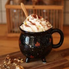 a black pot filled with whipped cream on top of a wooden cutting board