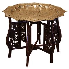 an ornately carved wooden table with metal tray