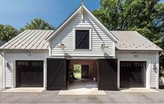 a white house with two black garage doors