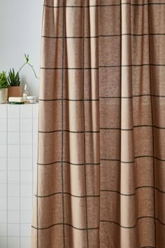 a bathroom with a shower curtain and tiled floor