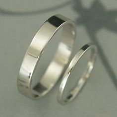 two wedding rings sitting next to each other