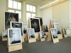 an assortment of framed photographs are on display in a room with carpeted flooring