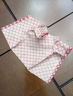 an umbrella laying on the ground in front of a tile floor with red and white designs